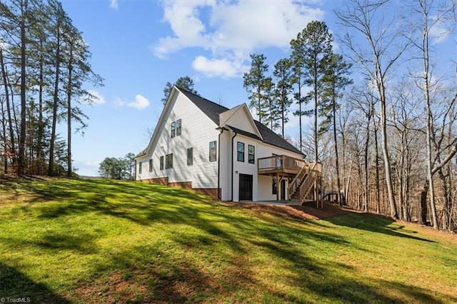 back of property featuring stairway, a lawn, and a wooden deck