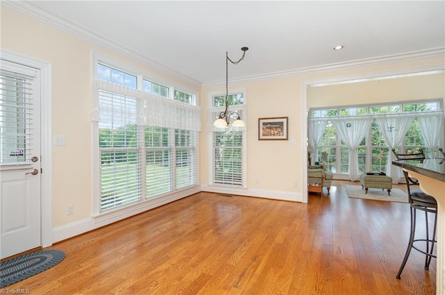 7469 Henson Forest Dr, Summerfield, NC 27358 - dining room with baseboards, crown molding, light wood finished floors, and a chandelier