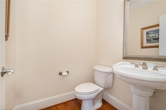 7469 Henson Forest Dr, Summerfield, NC 27358 - half bath with baseboards, toilet, wood finished floors, and a sink