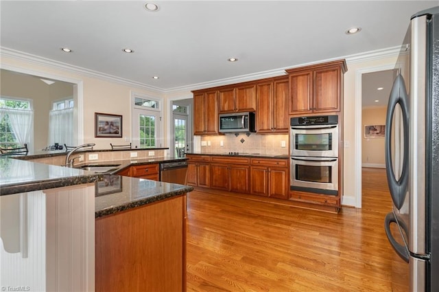 7469 Henson Forest Dr, Summerfield, NC 27358 - kitchen with appliances with stainless steel finishes, light wood-type flooring, a sink, healthy amount of natural light, and recessed lighting