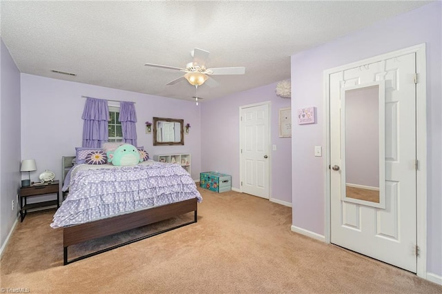 bedroom featuring visible vents, baseboards, ceiling fan, light colored carpet, and a textured ceiling