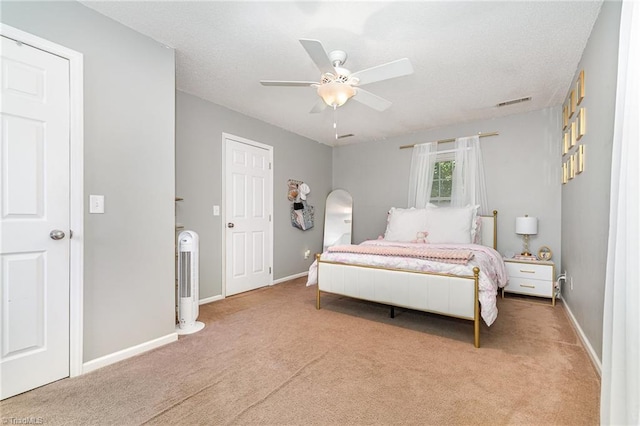 carpeted bedroom with baseboards, ceiling fan, and visible vents
