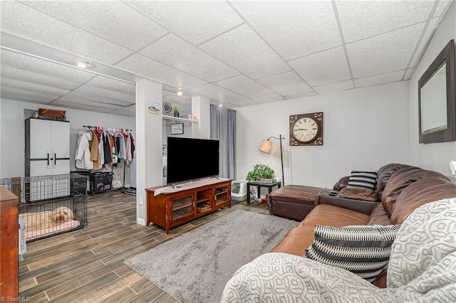 living area featuring wood finish floors and a paneled ceiling