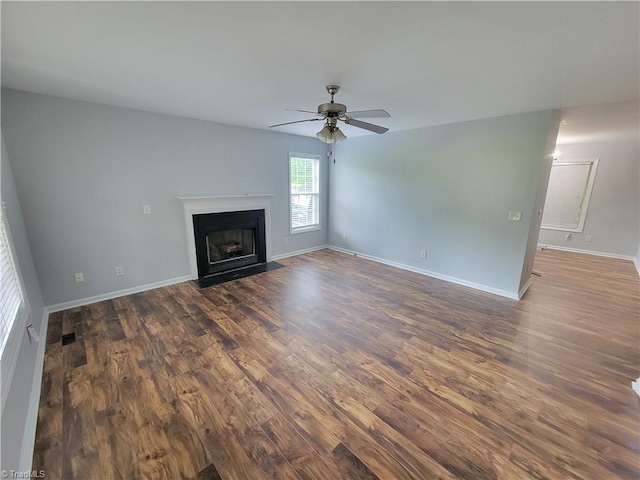 unfurnished living room featuring ceiling fan and dark hardwood / wood-style floors