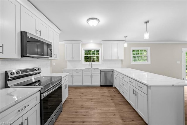 2517 Hopewell Friends Rd, Asheboro, NC 27205 - kitchen featuring appliances with stainless steel finishes, a peninsula, light wood-type flooring, white cabinets, and decorative backsplash