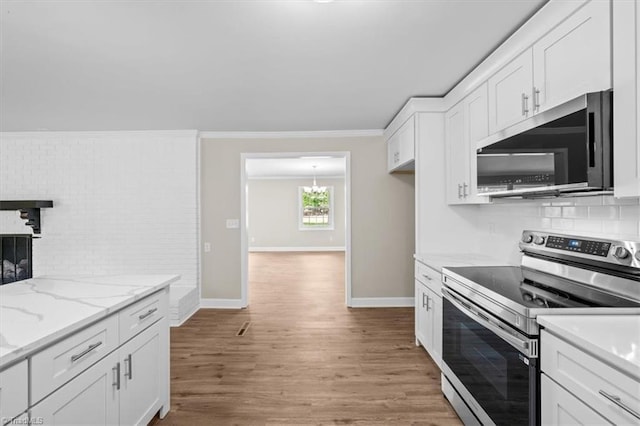 2517 Hopewell Friends Rd, Asheboro, NC 27205 - kitchen with stainless steel appliances, decorative backsplash, white cabinets, crown molding, and light wood-style floors