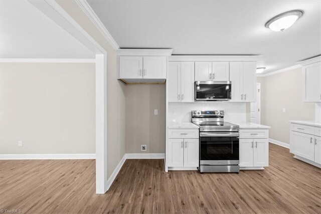 2517 Hopewell Friends Rd, Asheboro, NC 27205 - kitchen featuring stainless steel appliances, light wood-type flooring, white cabinets, light countertops, and ornamental molding