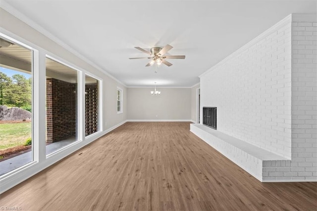 2517 Hopewell Friends Rd, Asheboro, NC 27205 - unfurnished living room with wood finished floors, a chandelier, crown molding, ceiling fan, and brick wall