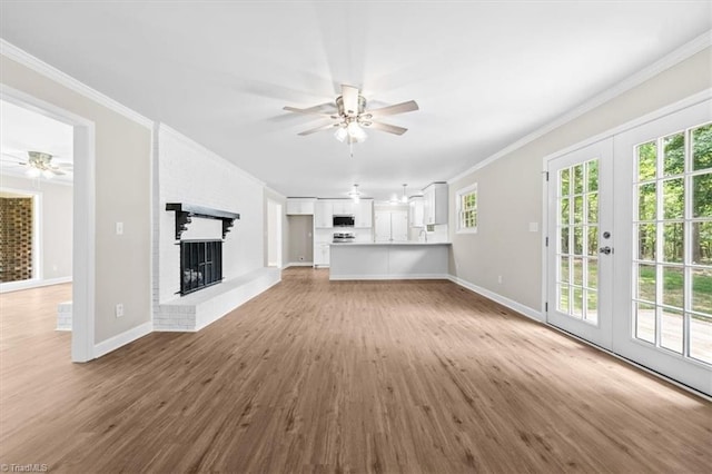 2517 Hopewell Friends Rd, Asheboro, NC 27205 - unfurnished living room featuring a ceiling fan, crown molding, wood finished floors, plenty of natural light, and a brick fireplace