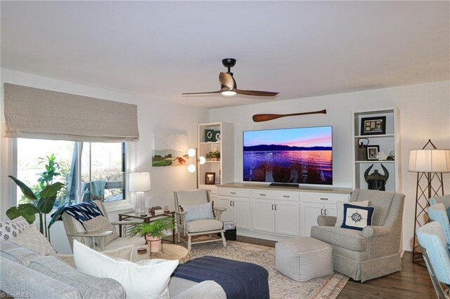 living area featuring dark wood-type flooring and ceiling fan