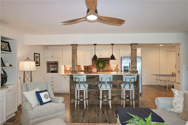 living area with dark wood finished floors and ceiling fan