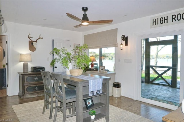 dining area with baseboards, wood finished floors, and a ceiling fan