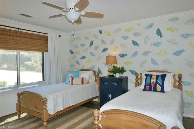 bedroom featuring crown molding, wallpapered walls, wood finished floors, baseboards, and visible vents