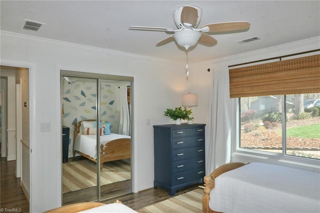 bedroom featuring wood finished floors, crown molding, and visible vents