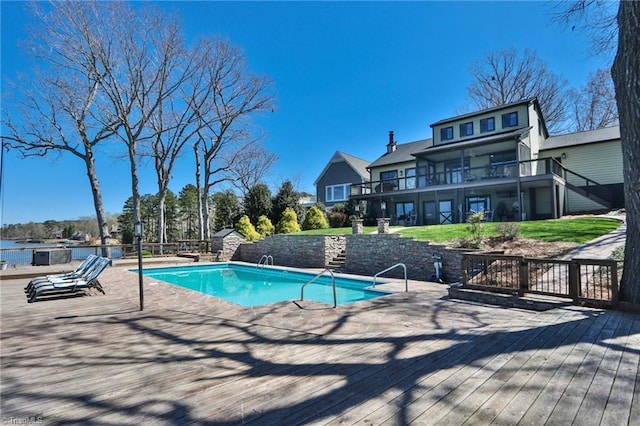 view of pool featuring a patio area, a fenced in pool, stairs, and a wooden deck