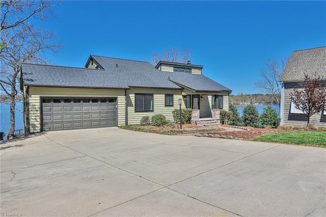 view of front of property with a water view, an attached garage, and concrete driveway