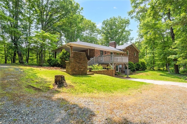 2665 Kecoughtan Rd, Pfafftown, NC 27040 - view of front of home featuring driveway, brick siding, a chimney, a front lawn, and a wooden deck