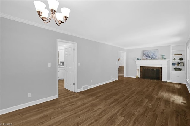 2665 Kecoughtan Rd, Pfafftown, NC 27040 - unfurnished living room featuring a chandelier, built in shelves, dark wood-style floors, baseboards, and a brick fireplace