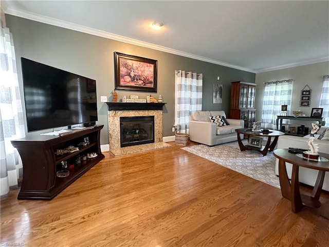 living room featuring a fireplace, light wood-type flooring, plenty of natural light, and crown molding