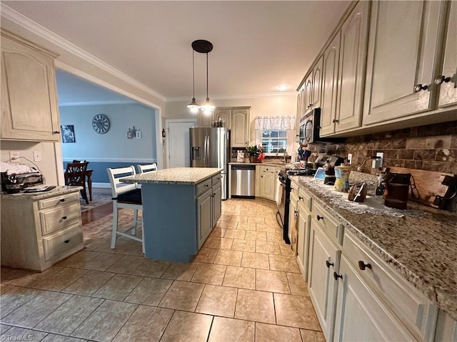 kitchen featuring pendant lighting, decorative backsplash, a kitchen island, appliances with stainless steel finishes, and ornamental molding