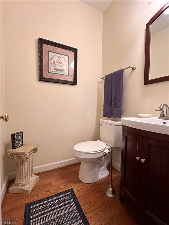 bathroom featuring toilet, vanity, and hardwood / wood-style flooring