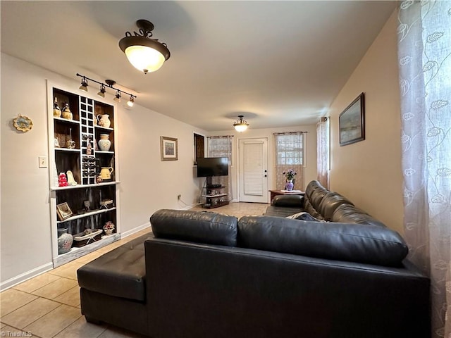 living room featuring rail lighting and light tile patterned flooring