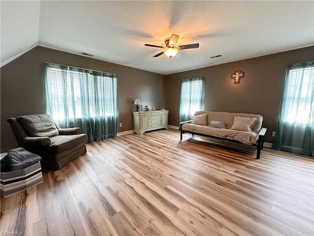 living area with lofted ceiling, ceiling fan, and light hardwood / wood-style floors