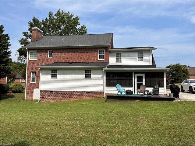 rear view of property with a yard and a sunroom