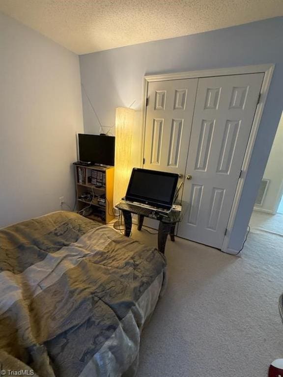 carpeted bedroom featuring a textured ceiling and a closet