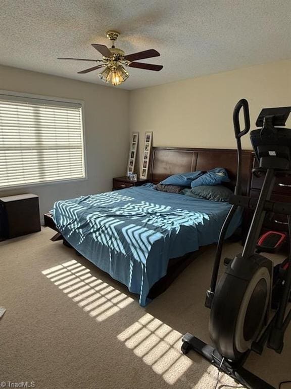 carpeted bedroom with ceiling fan and a textured ceiling