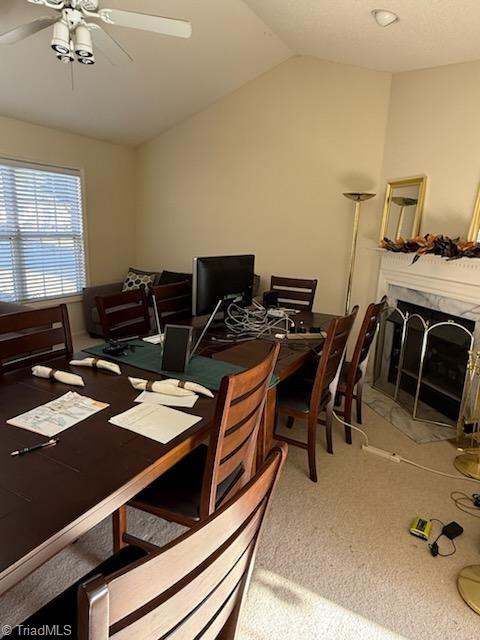 office area with carpet floors, a fireplace, vaulted ceiling, and ceiling fan