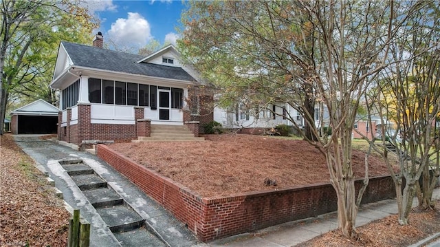 view of front of house with a sunroom, an outdoor structure, and a garage