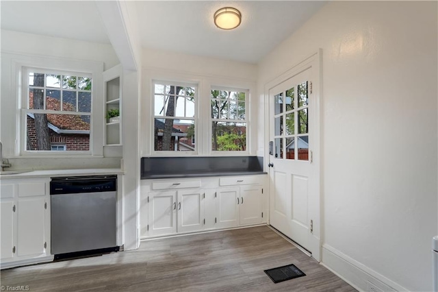 interior space with light hardwood / wood-style flooring, white cabinets, and stainless steel dishwasher