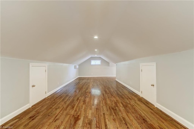 additional living space featuring lofted ceiling and hardwood / wood-style flooring