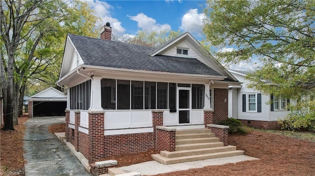 view of front of house with a sunroom, an outbuilding, and a garage