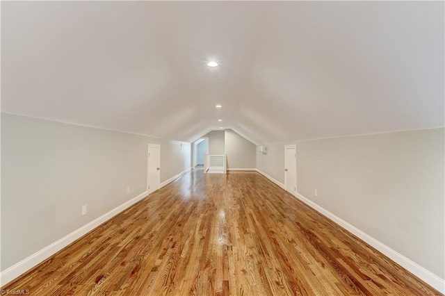 bonus room with vaulted ceiling and light hardwood / wood-style flooring