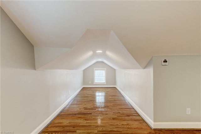 additional living space featuring hardwood / wood-style floors and vaulted ceiling