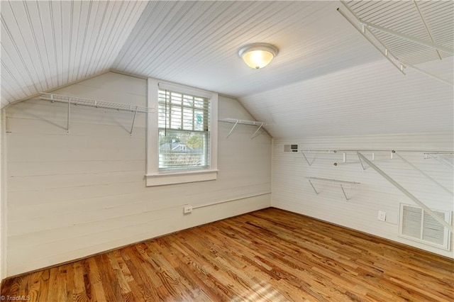 bonus room with hardwood / wood-style floors and vaulted ceiling