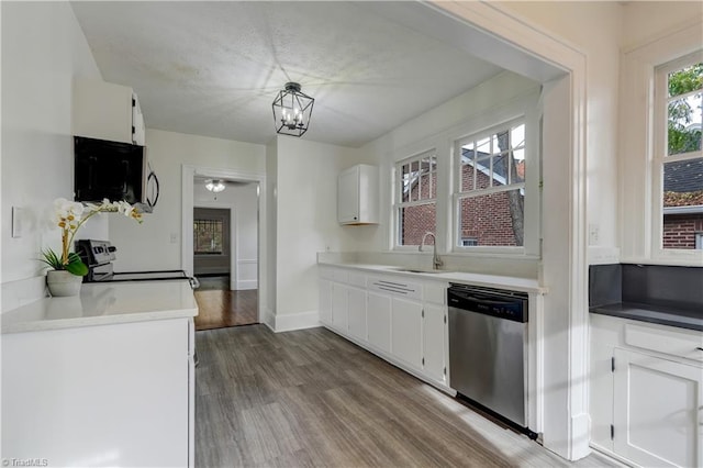 kitchen with white cabinets, sink, stainless steel dishwasher, hardwood / wood-style flooring, and range