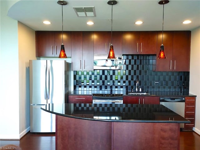 kitchen with dark hardwood / wood-style floors, hanging light fixtures, tasteful backsplash, appliances with stainless steel finishes, and sink