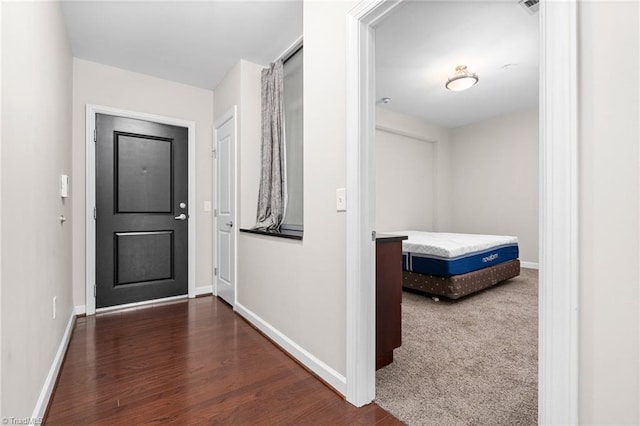 hall featuring dark colored carpet