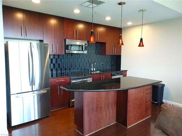 kitchen with dark hardwood / wood-style flooring, backsplash, a center island, appliances with stainless steel finishes, and sink