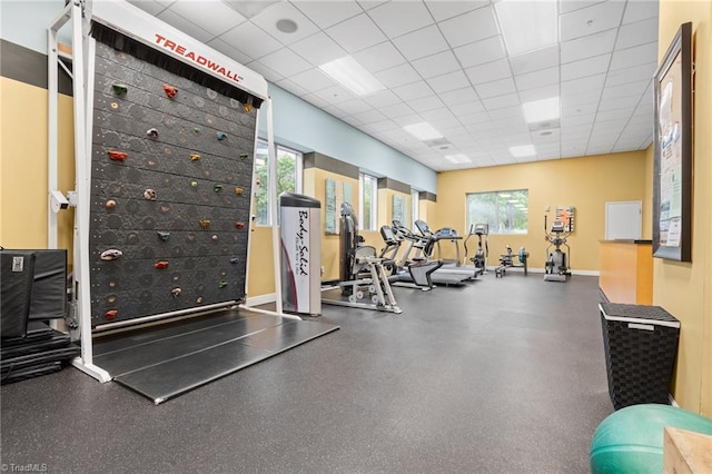 exercise room with plenty of natural light and a drop ceiling