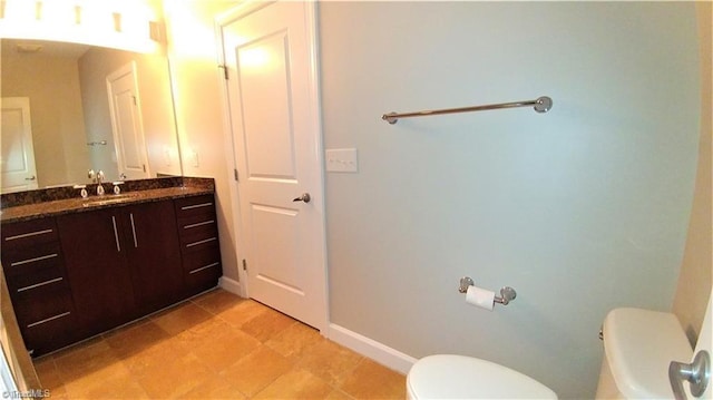 bathroom with tile flooring, vanity, and toilet