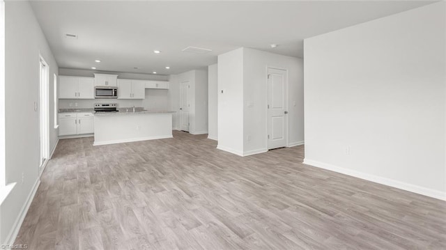 1529 String Dr, Winston-Salem, NC 27107 - unfurnished living room featuring light wood-style floors, baseboards, recessed lighting, and a sink