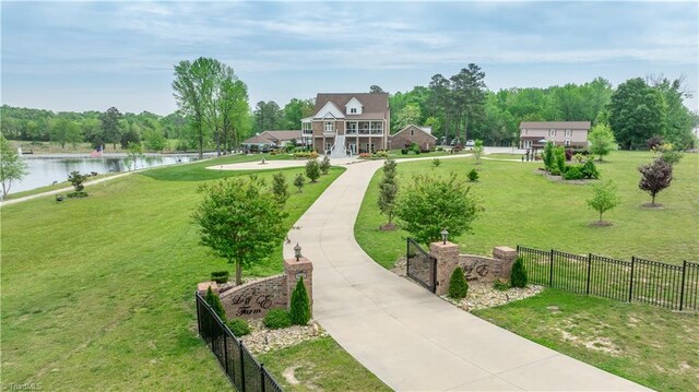 view of home's community with a water view and a lawn