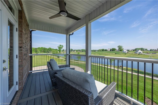 balcony featuring a water view and ceiling fan