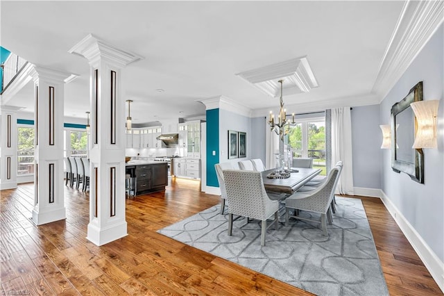 dining area with decorative columns, wood finished floors, crown molding, and a chandelier