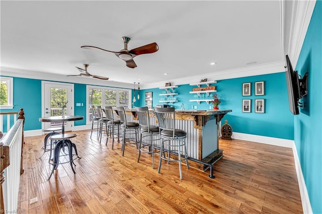 kitchen with crown molding, light wood-type flooring, and baseboards