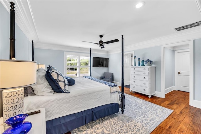 bedroom with visible vents, baseboards, hardwood / wood-style floors, ornamental molding, and a ceiling fan